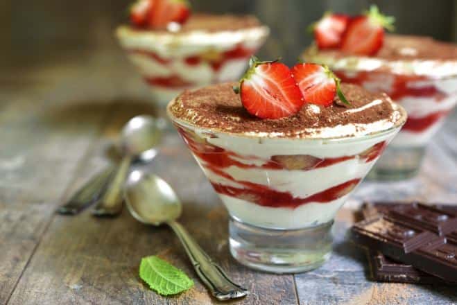 Quatre petits desserts tiramisu dans des coupes en verre avec une affiche  de jardin de